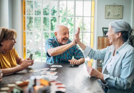 Group of retirees having fun playing cards