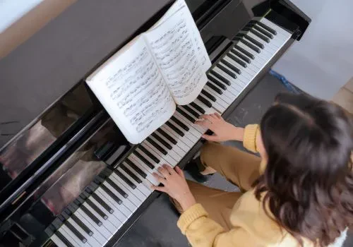 A woman playing a solitary piano